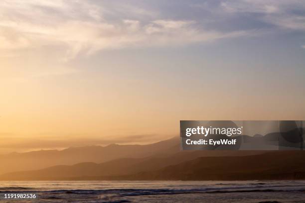 a bright orange sunset over the pacific ocean looking at the santa ynez mountains - サンタイネス ストックフォトと画像
