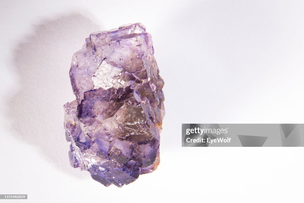 An amethyst crystal on a white background
