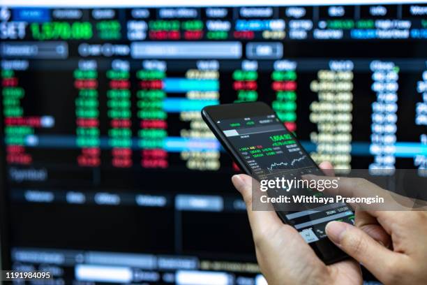 businessman checking stock market data. he using a mobile phone. analysis economy data on forex earn graph. - cambio valuta foto e immagini stock