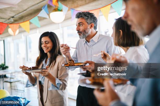 colegas comiendo pastel en la fiesta de cumpleaños de la oficina - cumpleaños tarta fotografías e imágenes de stock