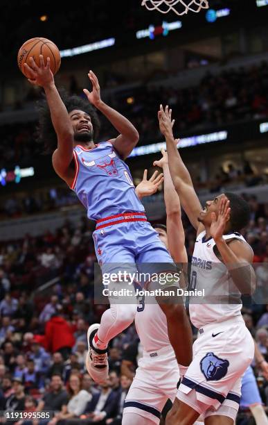 Coby White of the Chicago Bulls puts up a shot against De'Anthony Melton and Grayson Allen of the Memphis Grizzlies at the United Center on December...