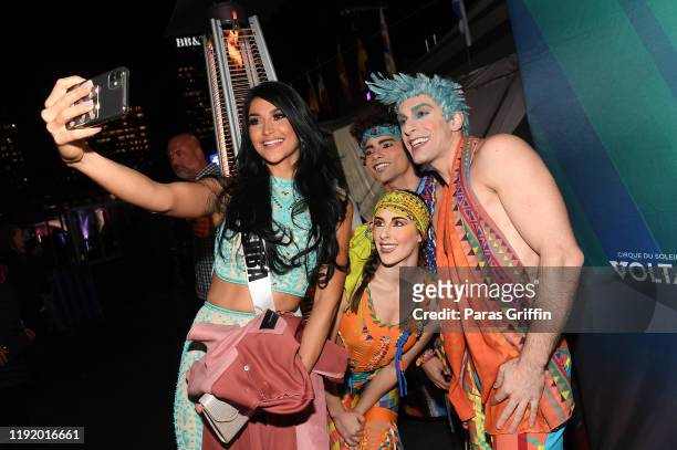 Miss Aruba Danna Garcia poses with members of Volta By Cirque Du Soleil cast members during Volta By Cirque Du Soleil at Atlantic Station on December...
