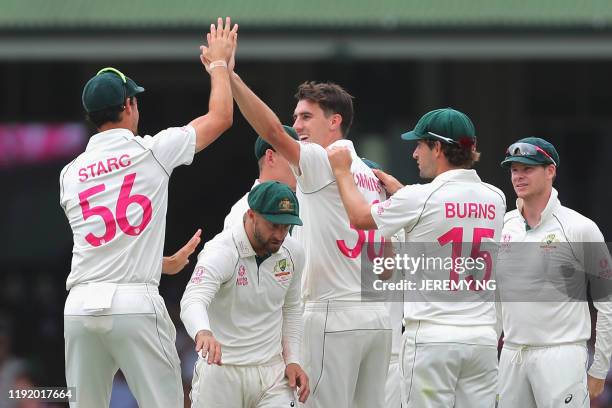 The Australian team and Pat Cummins celebrate the wicket of New Zealand's Ross Taylor during the fourth day of the third cricket Test match between...