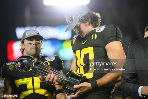 Oregon Ducks Justin Herbert looks down at the trophy after the Rose Bowl game between the Wisconsin Badgers and the Oregon Ducks on January 1, 2020...