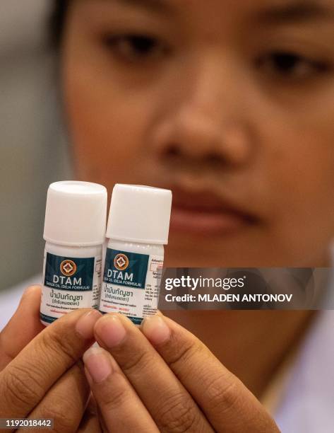 Nurse looks at vials with cannabidiol oil during the opening of a cannabis clinic at the Department of Development of Thai Traditional and...