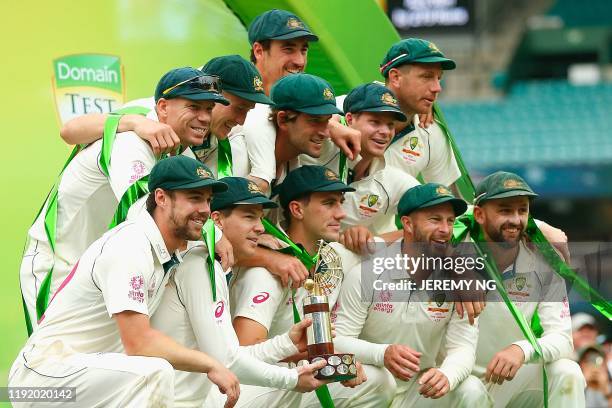 The Australian team poses with the Trans-Tasman Trophy after winning the series on the fourth day of the third cricket Test match between Australia...