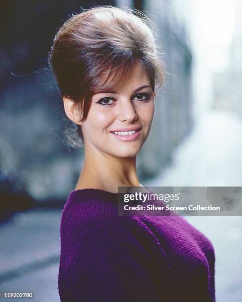 Claudia Cardinale, Italian actress, with a beehive hairstyle, wearing a purple jumper, circa 1960.