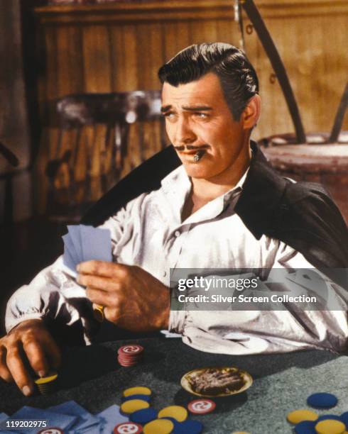 Clark Gable , US actor, playing cards and smoking a cigar in a publicity still issued for the film, 'Gone With The Wind', USA, 1939. The 1939 drama,...