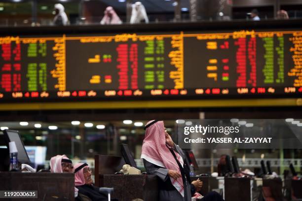 Kuwaiti traders follow stock prices at Boursa Kuwait stock market, in Kuwait City on January 6, 2020. - Gulf stock markets were hit by a panicky...