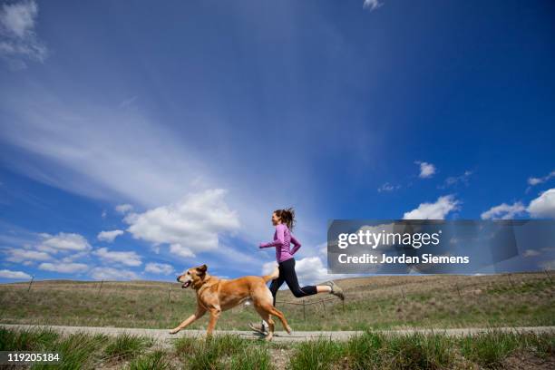 a woman and her dog jogging. - 犬　走る ストックフォトと画像