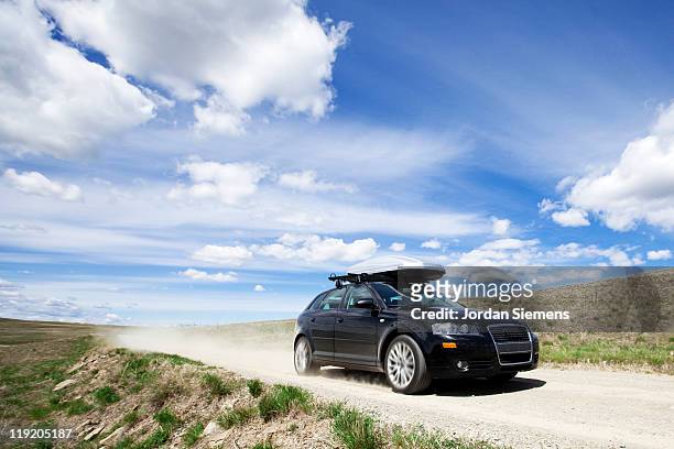 car speeding down dirt road. - country roads stock pictures, royalty-free photos & images