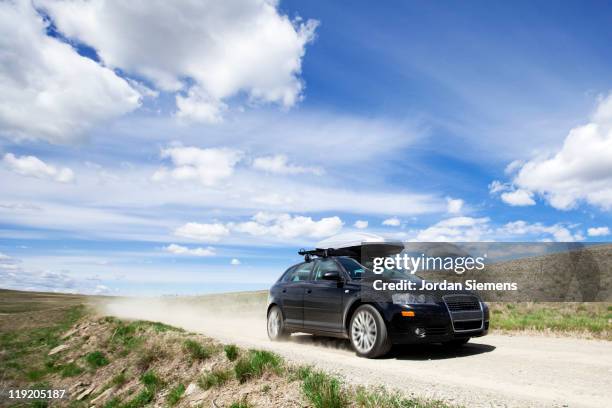 car speeding down dirt road. - montana summer landscape stock pictures, royalty-free photos & images