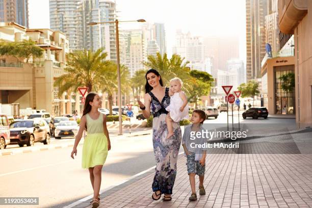 moeder met kinderen wandelen rond de stad. - city walk dubai stockfoto's en -beelden