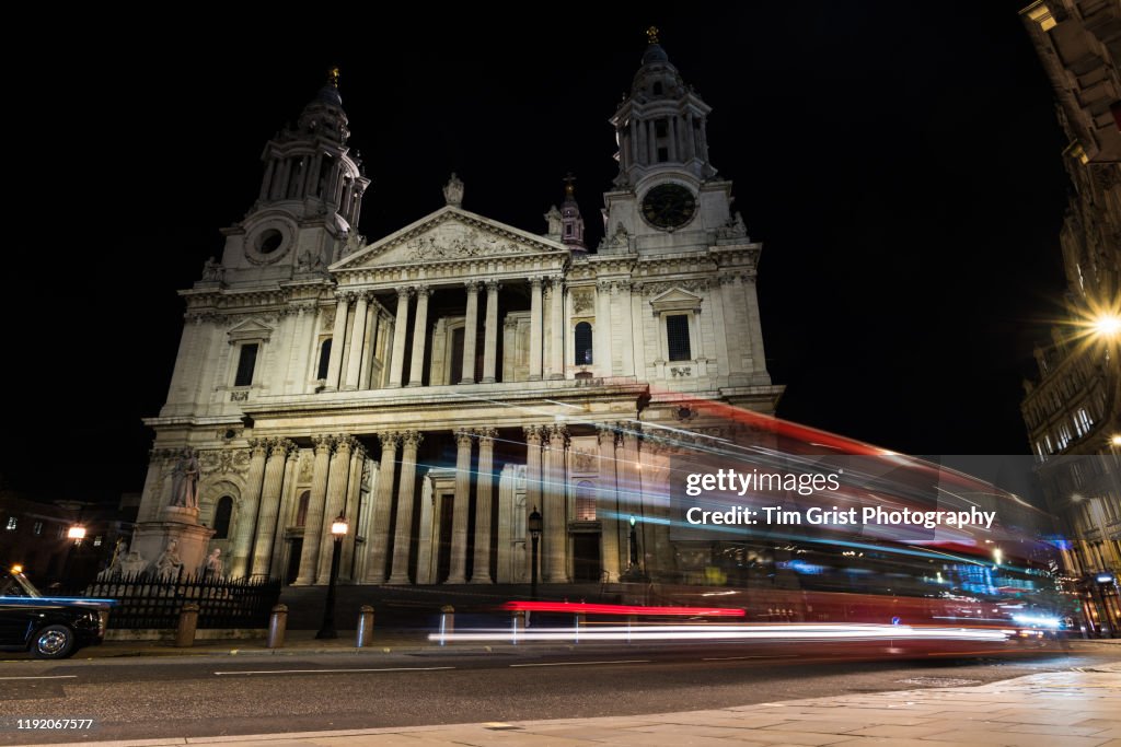 Red Double Decker Bus on a City Street at Night Opposite St Paul's Cathedral, London, UK