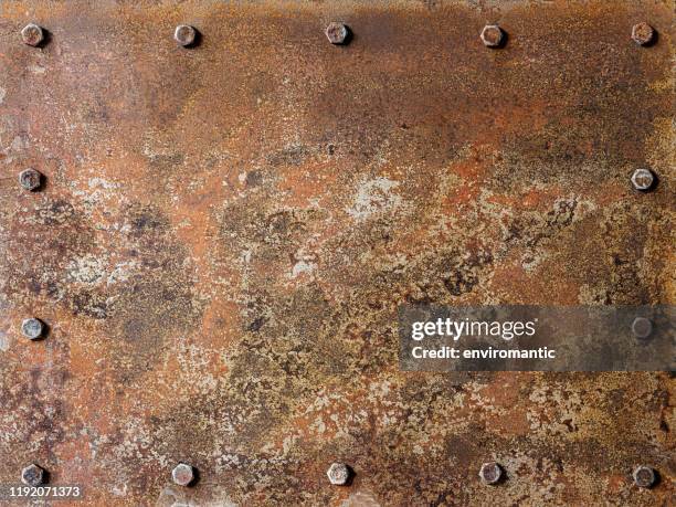 粗糙的老五色生銹和patina覆蓋抽象金屬板背景與螺栓周圍的板的邊緣，許多侵蝕字元。 - rusty 個照片及圖片檔