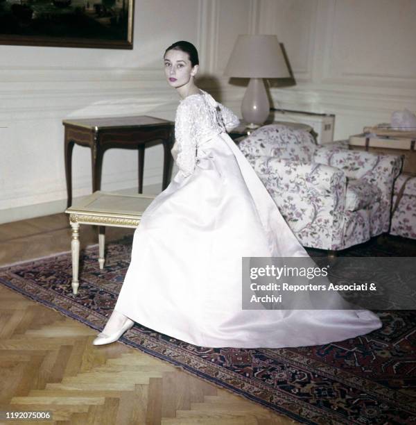 British actress Audrey Hepburn posing with a dress by French stylist Hubert de Givenchy. Paris, 1958