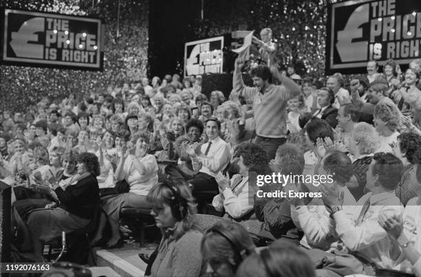 Contestant enthusiastically runs down the stairs in the television studio of "The Price Is Right", UK, 15th December 1984.