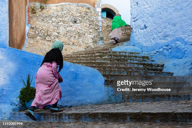 women walking up steps in the medina of chefchaouen - chefchaouen medina stock pictures, royalty-free photos & images