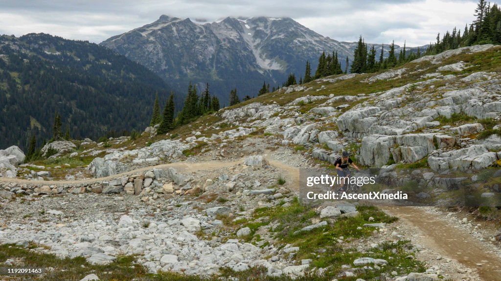 Female mountain biker rides through high alpine environment