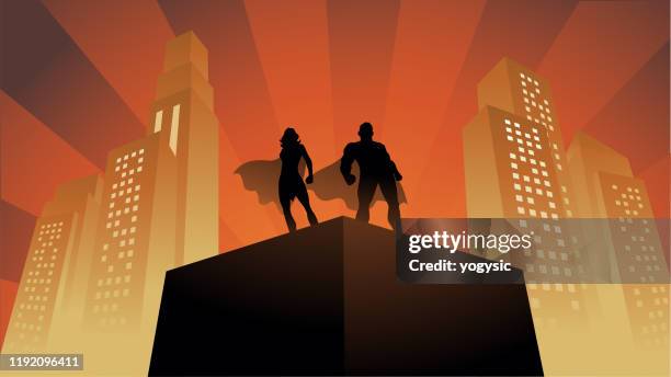 vektor-superhelden-paar silhouette auf einem dach mit gebäuden im hintergrund - superhero cartoon stock-grafiken, -clipart, -cartoons und -symbole