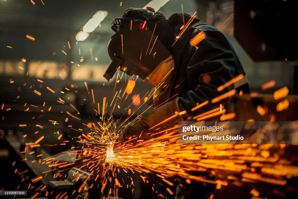 Metal worker using a grinder