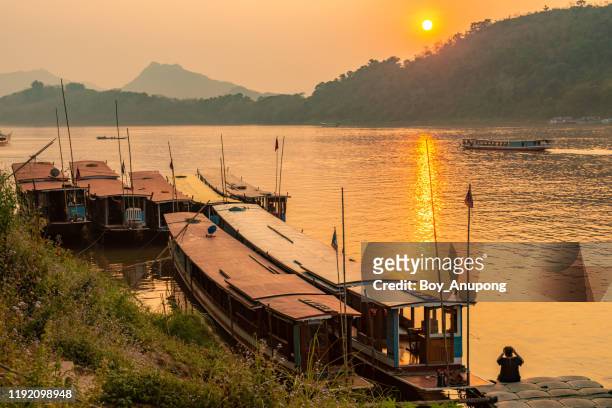 the local boat with beautiful sunset view over mekong river in luang prabang, laos. - laos stock-fotos und bilder