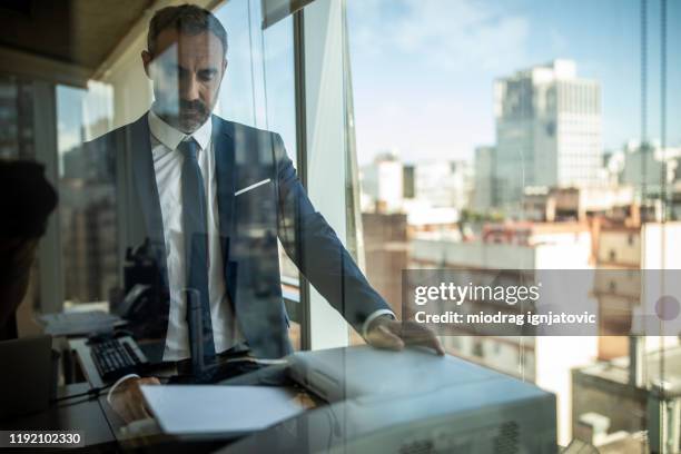 homme d'affaires latino utilisant la photocopieuse au travail - imprimante photos et images de collection