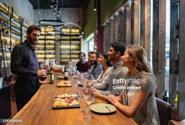 sommelier praat met een groep mensen wijnproeverij in een kelder - sommelier stockfoto's en -beelden