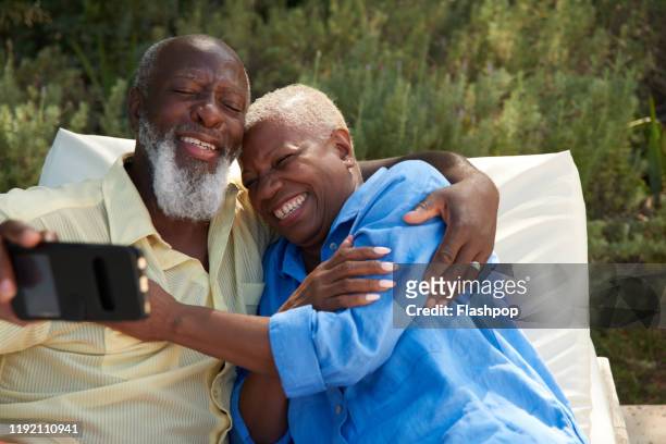 Mature couple laugh taking selfies