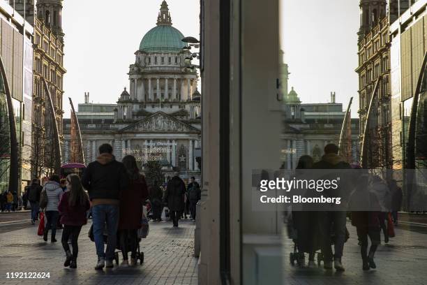 Shoppers walk along Donegall Place in view of the Belfast City Hall in Belfast, Northern Ireland, U.K., on Friday, Jan. 3, 2020. Nationalists who...
