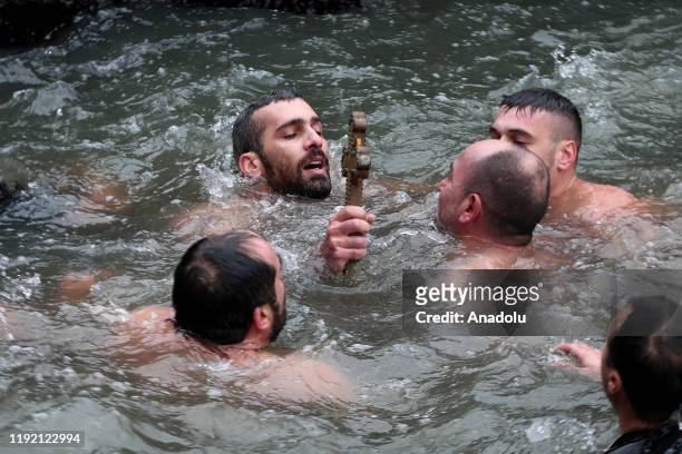 Greek Orthodox faithful Nikolaos Solis catches wooden crucifix thrown into water during the Orthodox Epiphany Day marking the anniversary of Jesus's...