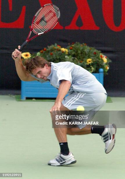 Jan-Michael Gambill of the US hits a return to Russia's Mikhail Yuzhny during their Qatar Open semi-final match in Doha Qatar 03 January 2003.