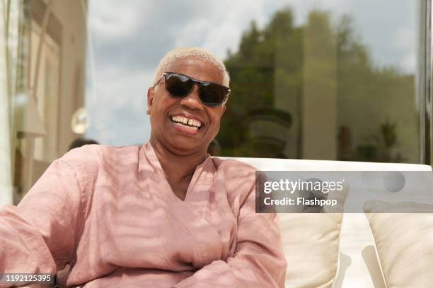 a mature woman laughs - sunglasses woman stock pictures, royalty-free photos & images