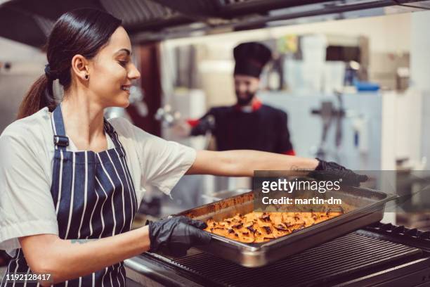 female chef working in the hotel kitchen - cafeteria stock pictures, royalty-free photos & images
