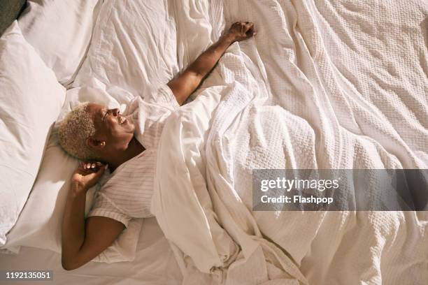 mature woman in bed (morning) - réveil matin photos et images de collection