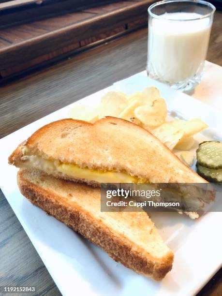 grilled cheese sandwich with potato chips, pickles, and milk - grilled cheese stock pictures, royalty-free photos & images