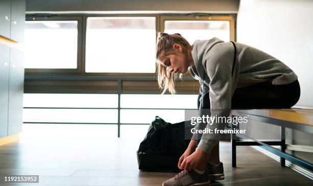 junge frau bereitet sich auf ausbildung in umkleidekabine vor - sporttasche stock-fotos und bilder