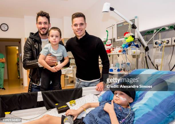 Goalkeeper Roman Buerki and Julian Weigl of Borussia Dortmund pose with kids during the annual visit at the Children's Hospital on December 04, 2019...