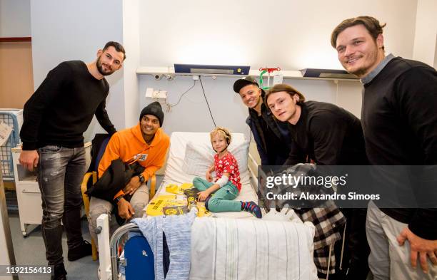 Goalkeeper Eric Oelschlaegel, Manuel Akanji, Jadon Sancho, Nico Schulz and assistant coach Edin Terzic of Borussia Dortmund pose with a kid during...