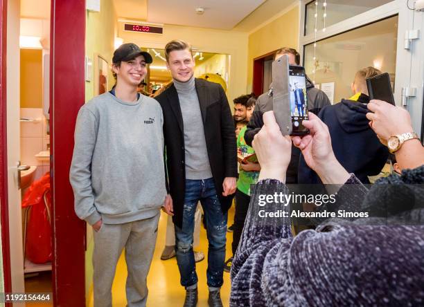 Lukasz Piszczek of Borussia Dortmund poses with a kid during the annual visit at the Children's Hospital on December 04, 2019 in Dortmund, Germany.