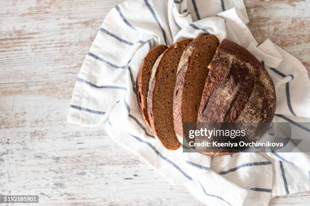 top view of sliced wholegrain bread on dark ructic wooden background closeup - center back stock-fotos und bilder