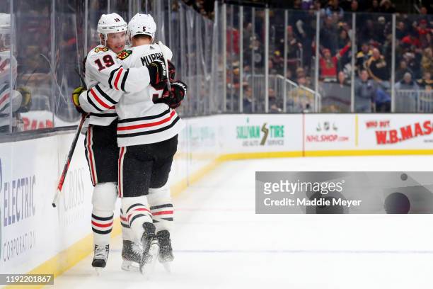 Jonathan Toews of the Chicago Blackhawks celebrates with Connor Murphy after scoring the game winning goal in overtime to defeat the Boston Bruins...