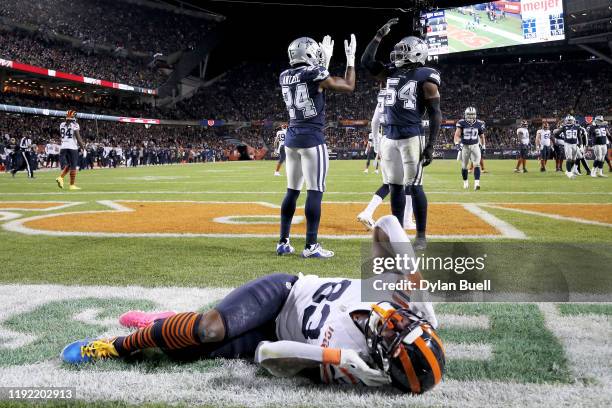Chidobe Awuzie and Jaylon Smith of the Dallas Cowboys celebrate as Javon Wims of the Chicago Bears lies injured on the field in the second quarter at...