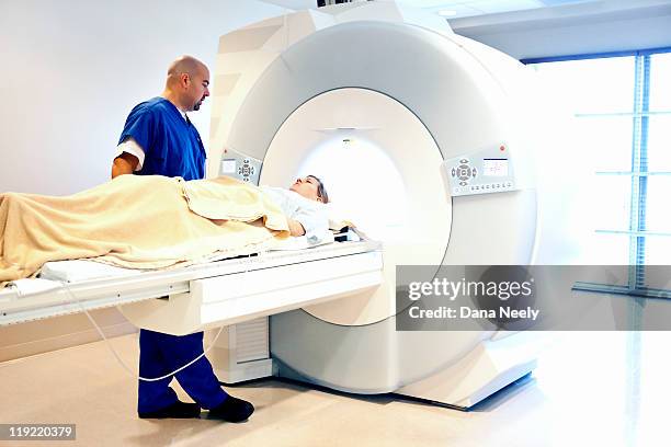 technician with patient undergoing mri scan - mri technician stock pictures, royalty-free photos & images