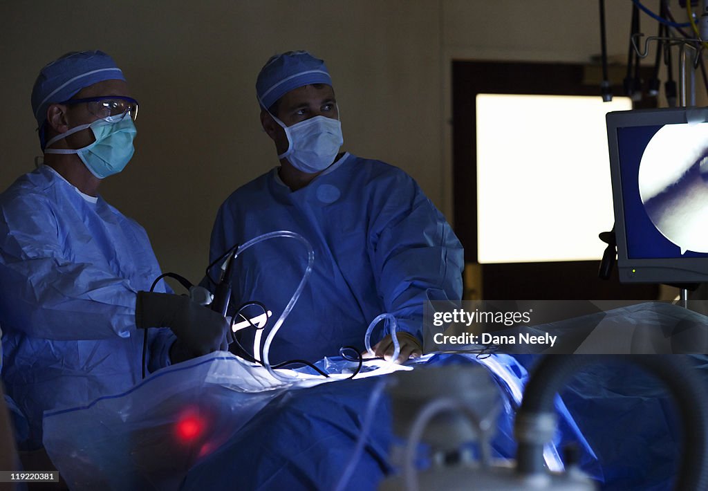Surgeon performing laproscopic surgery on hip.