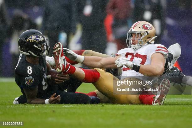 Lamar Jackson of the Baltimore Ravens is tackled by Nick Bosa of the San Francisco 49ers during the first half at M&T Bank Stadium on December 1,...