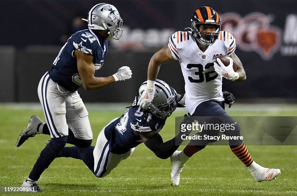 Running back David Montgomery of the Chicago Bears carries the ball against the defense of middle linebacker Jaylon Smith and cornerback Byron Jones...