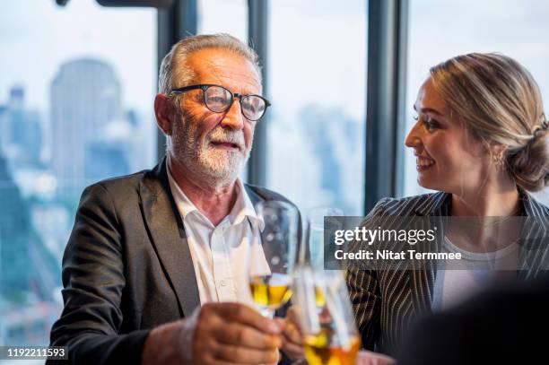 business success concepts. senior business man and secretary enjoying some party at hotel. - global business continuity stock pictures, royalty-free photos & images