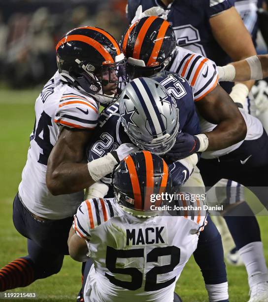 Ezekiel Elliott of the Dallas Cowboys is dropped for a loss by Khalil Mack, Leonard Floyd and Kevin Pierre-Louis of the Chicago Bears at Soldier...