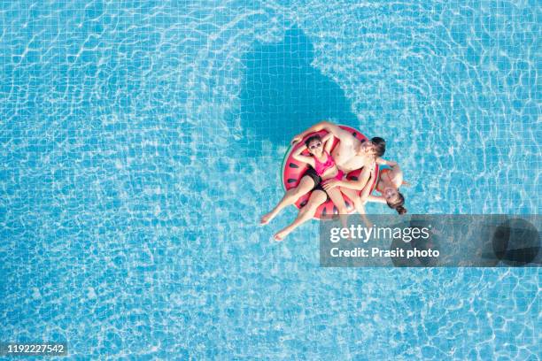 aerial view of happy asianfamily in the pool, having fun in the water, father, mother with daughter enjoying aqua park in resort, summer holidays, vacation concept - happy holidays family stock pictures, royalty-free photos & images